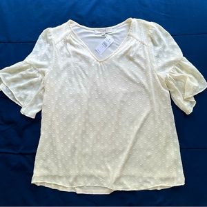 Cream blouse with raised circle design.